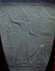 Narmerova paleta: obřadní paleta zobrazující krále Narmera s bílou korunou Horního Egypta, jak udeří zajatce, nalezená v Hierakonpolisu, raně dynastické období, kolem 3000 př. n. l.