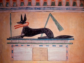 Anubis se šakalí hlavou, bůh mumifikace. Stěna hrobky prince Khaemweseta II (malovaná vápencová výzdoba, 20. dynastie)