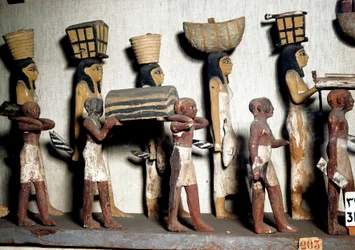 Egyptský antiquite: sochařská skupina z malovaného dřeva představující služebníky nesoucí obětiny zemřelému. Káhira, Egyptské muzeum