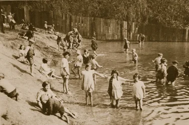 Děti si hrají v rybníku Hampstead (sépiová fotografie)