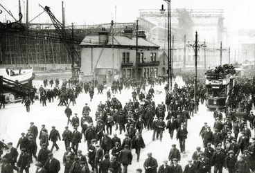 Zahajovací čas v loděnici Harland and Wolff, Belfast, Irsko s rozestavěným Titanikem v pozadí, 1910-11