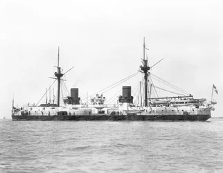 Pohled na obrněnou bitevní loď HMS Inflexible (spuštěna 1876) na snímku po přestavbě na vojenskou plošinu v roce 1885 (černobílá fotografie)