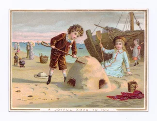 Viktoriánská vánoční pohlednice s chlapcem stavějícím hrad z písku na pláži, cca 1880 (barevná litografie)