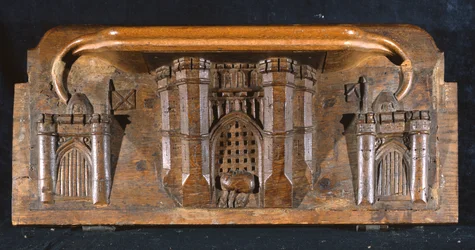 Misericord zobrazující koně Sira Yvainse uvězněného, když se spouští padací mříž propracovaného vstupu do hradu, New College Chapel, Oxford, konec 14. století (dřevo)