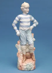 Bisque figurka fotbalového chlapce v modrobílé pruhované soupravě, cca 1890 (keramika)