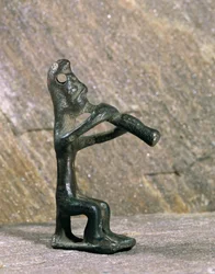 Hráč na flétnu. Bronzová figurka z Byblu v Libanonu...