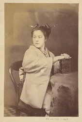 [Sedící Japonka držící u stolu album cartes-de-visite]