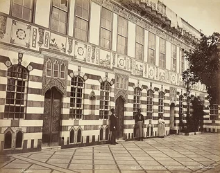 Nádvoří židovského domu v Stambouli, Sýrie, U zdí budovy jsou zobrazeni tři domácí