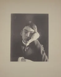 Chlapec v obleku s rukou proti obličeji, kolem roku 1896