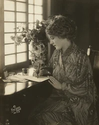 Mary Pickfordová, v kimonu, psací u stolu, cca 1918 (černobílá fotografie)