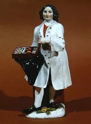 Míšeňská soška prodavače brýlí (porcelán)