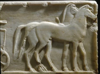 Řecké umění: „Koně kvadrigy“. Detail podstavce kúra (sochy mladého muže). Mramorový reliéf. 490 př. n. l. Národní archeologické muzeum, Athény