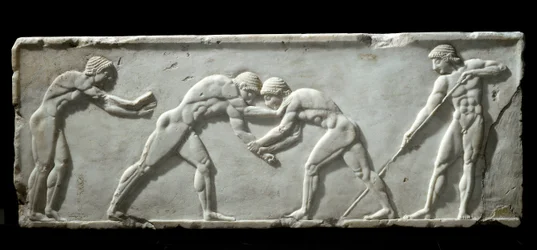 Řecké umění: podstavec kúra znázorňující zápasníky v boji. Mramorový reliéf, 510-500 př. n. l. - Athény, Archeologické muzeum