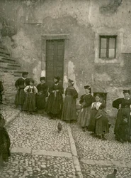 Ženy a děti v tradičních oděvech na schodech vedoucích k domu, Abruzzo, Itálie