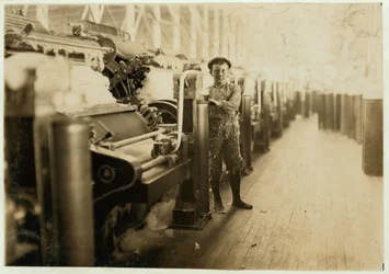 Chlapecký zametač na mykacích strojích v Lincoln Cotton Mills, Evansville, Indiana s nohama v punčochách na kluzké podlaze, 1908