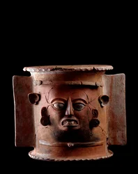 Předkolumbovské umění, mayská civilizace, pozdně klasické období: válcovitá hliněná pohřební urna zdobená lidskou tváří. Z Quiché, Guatemala. Výška 33,5 x průměr 33 cm. Guatemala, Národní muzeum archeologie a etnologie