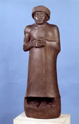 Mezopotámie: dioritová socha bez nápisu Gudei, vládce města Lagaš. Kolem 2150 př. n. l. Novosumerské období (asi 2150-2000 př. n. l.). Rozm. 1,07 x 1,36 m. Paříž, muzeum Louvre