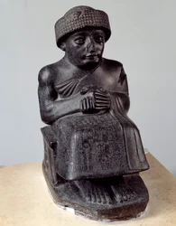 Mezopotámie: socha boha Ningishzidy zobrazující sedícího Gudeu, knížete z Lagaše. Novosumerské období (asi 2150-2000 př. n. l.). Paříž, muzeum Louvre