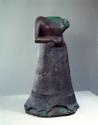 Elamská civilizace: bronzová socha královny Napir Asu s elamským nápisem. 1250 př. n. l. Z naleziště Súsy, Írán. V 1,29 x 0,73 m. Paříž, Musée du Louvre