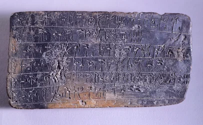 Hliněná tabulka s nápisem v lineárním písmu B z archivů Nestorova paláce v Pylu (Řecko), mykénská civilizace, kolem 13. století př. n. l.