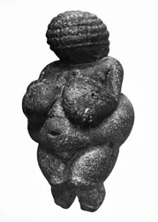 Venuše z Willendorfu, boční pohled na ženskou figurku, gravettien, mladý paleolit, kolem 30000-18000 př. n. l. (oolitický vápenec zbarvený červeným okrem)