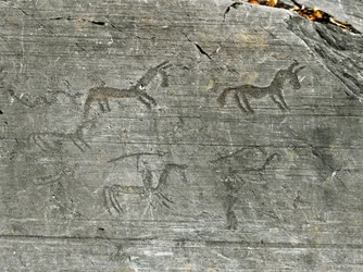 Pravěk, civilizace Camunnů, skalní umění: rytá skála s loveckým výjevem, lovec se ohání kopím. Období mezi neolitem a dobou bronzovou. Capo di Ponte, Národní park skalních rytin v Naquane, Valcamonica, Val Camonica, Itálie