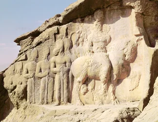 Skalní reliéf zobrazující Šapura I. (241–272 n. l.) a jeho rodinu s heraldickými emblémy na kloboucích (foto)