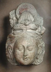 Hlava bódhisattvy s propracovaným účesem, z Tumshuq (Xinjiang) 6.-7. století (terakota)