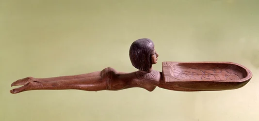 Egyptské starožitnosti: dřevěná lžíce na kosmetiku ve tvaru nahé plavkyně držící kachnu. 18. dynastie, Nová říše. Paříž, muzeum Louvre
