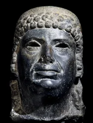 Hlava Kleopatry III., čedičová socha. Egyptská civilizace, ptolemaiovské období, 2. století př. n. l.