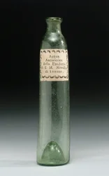 Láhev, která obsahovala vodu proti hysterii, ze slévárny Jeho královské Výsosti, Officina Profumo, Farmaceutica di Santa Maria Novella, Florencie, kolem 1850-1920 (sklo)