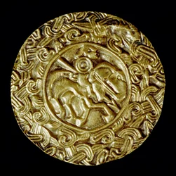 Archeologie středověku (středověk). Barbarské umění Lombardie: zlatý kotouč. Uprostřed je světec na koni s kopím a kolem zvířecích motivů. Lombardské umění, kolem 600. Rozměr: 47 cm Itálie, Cividale del Friuli, Archeologické muzeum