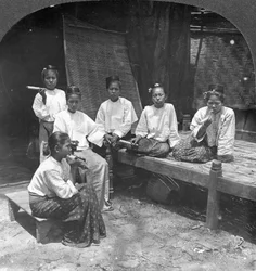 Barmské ženy kouřící mimo svůj domov, Mandalay, Barma, 1908.