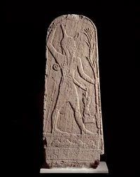 Orientální umění: stéla boha Baala v blesku. (Bůh válečník chránící krále) Socha z 15. století př. n. l., Sýrie. Paříž, Musée du Louvre