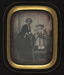 Dítě stojící na židli drží květiny, s matkou, c. 1855.