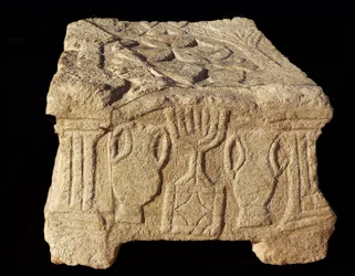 Reliéf zobrazující sedmiramennou menoru, synagoga Magdala (kámen)