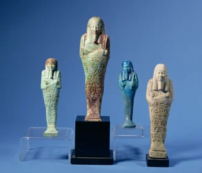 Čtyři zeleně nebo modře glazované postavy Shabti, tři s vodorovnými pásy hieroglyfického nápisu, egyptského, pocházejícího ze 7. až 3. století před naším letopočtem