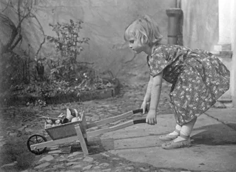 Holčička si hraje s kolečkem. Fotografie kolem roku 1931