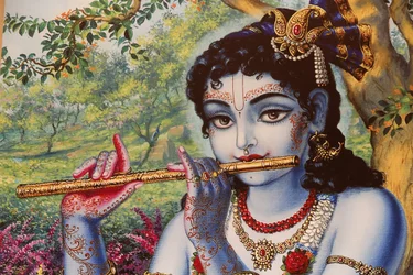 Obraz zobrazující hinduistického boha Krišnu hrajícího venku na flétnu. Indie
