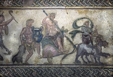 Římské umění: Dionýsův triumf (Bacchus, Bacco). Bůh vylezl na tank uprostřed. Má na sobě vavřínový věnec a drží tyrse (kopí obklopené břečťanem s šiškou na konci). Před ním postupují dva panteři. Za nádrží, a