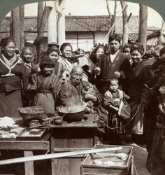 Pouliční umělec s opicí baví dav, Kobe, Japonsko, 1896.