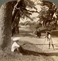 Cestovatelé odpočívající pod borovicemi v Suzukawě, staré poštovní silnici z Tokia do Kjóta, Japonsko, 1904.
