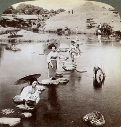 Ženy překračující jezero po odrazových můstcích, zahrada Suizen-ji, Kumamoto, Japonsko, 1904.