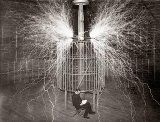 Nikola Tesla sedí ve své laboratoři v Colorado Springs se svým „zvětšovacím vysílačem“