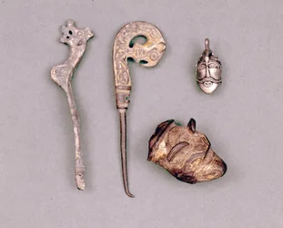 Různé kusy aparátů a vikingských šperků, vpravo nahoře znázornění božstva Odina. Stockholm, Historická Museet