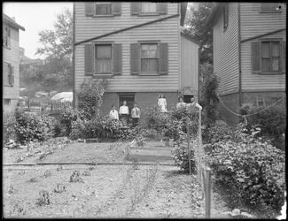Rodina pózuje vedle své zeleninové zahrady na dvorku, Inwood, New York, kolem roku 1910