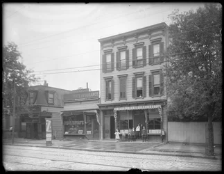 Sedm dětí pózuje před neidentifikovanou pobočkou veřejné knihovny Queens Borough, New York, kolem roku 1910