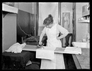Neznámá žena předvádí použití elektrické žehličky c.1913-14