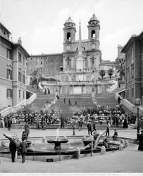 Pohled na Piazza di Spagna: v popředí Fontana della Barcaccia, za schodištěm obelisk a kostel Trinità dei Monti.